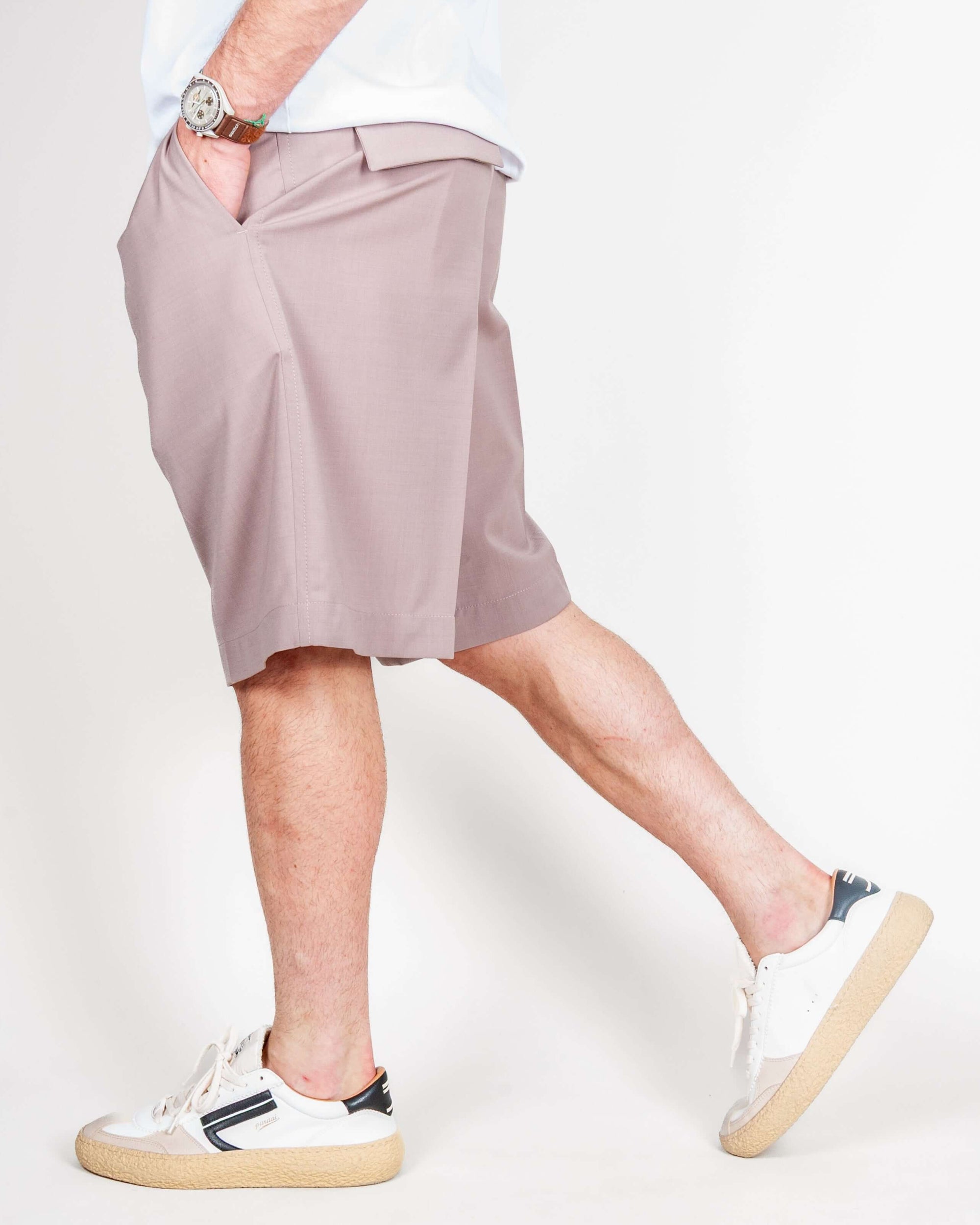 Uomo in Bermuda Fresco, Art. 0273700522, tessuto leggero con 54% Poliestere, 44% Lana e 2% Elastane, indossato con scarpe sportive.