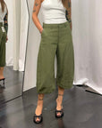 Bermuda lungo da lavoro donna verde con dettagli unici, indossato da una modella in uno specchio.