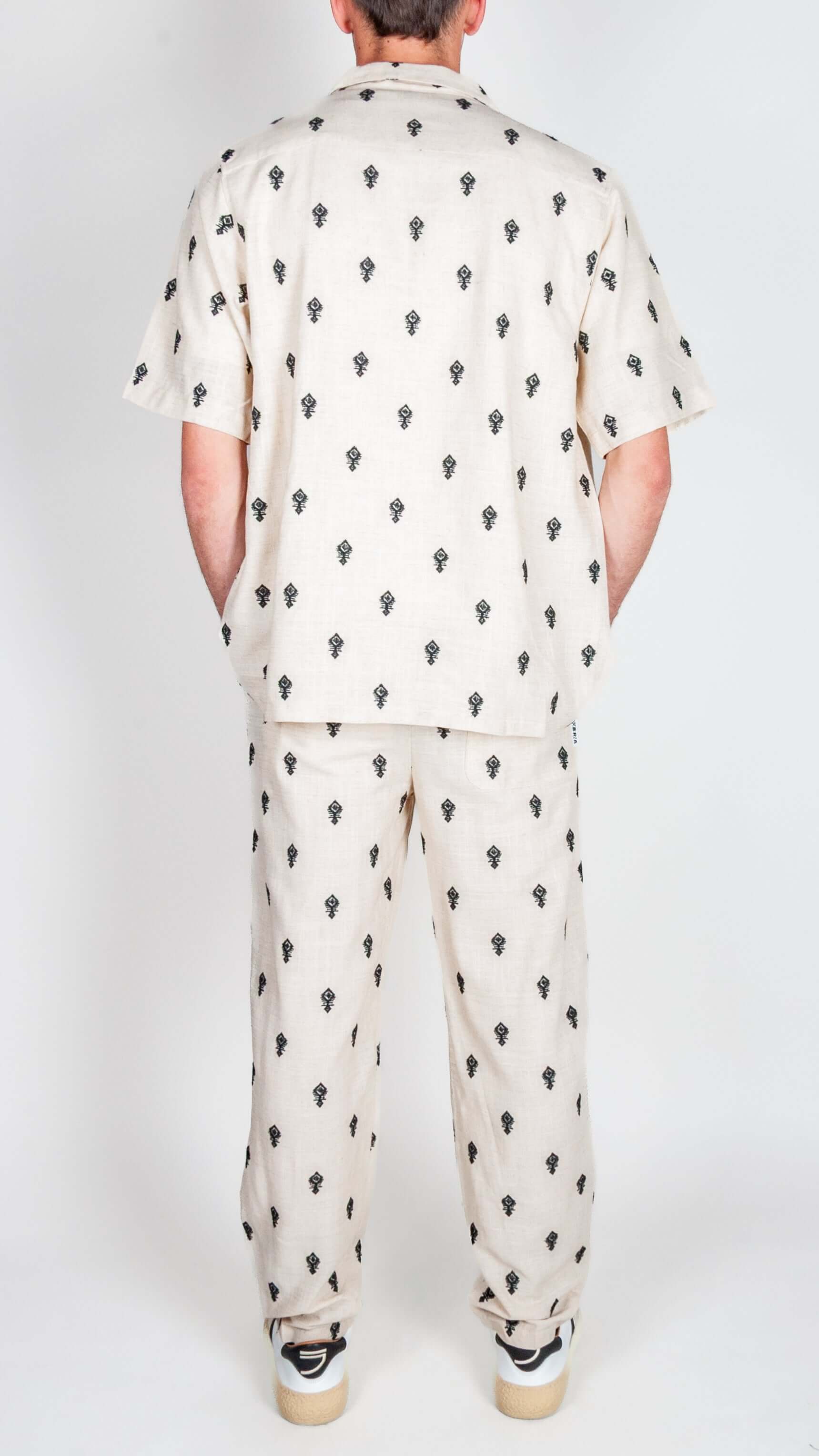 Completo Berna ricamo showcasing a stylish back view of the shirt and pants in a unique print design.