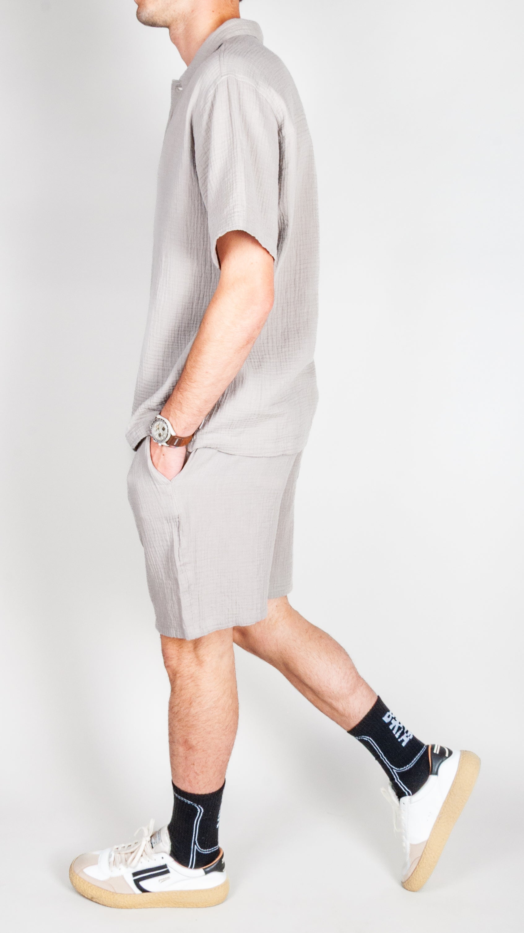 Completo goffrato Jack&amp;Jones worn by a man walking, featuring a light gray design and casual sneakers.