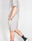 Completo goffrato Jack&Jones worn by a man walking, featuring a light gray design and casual sneakers.