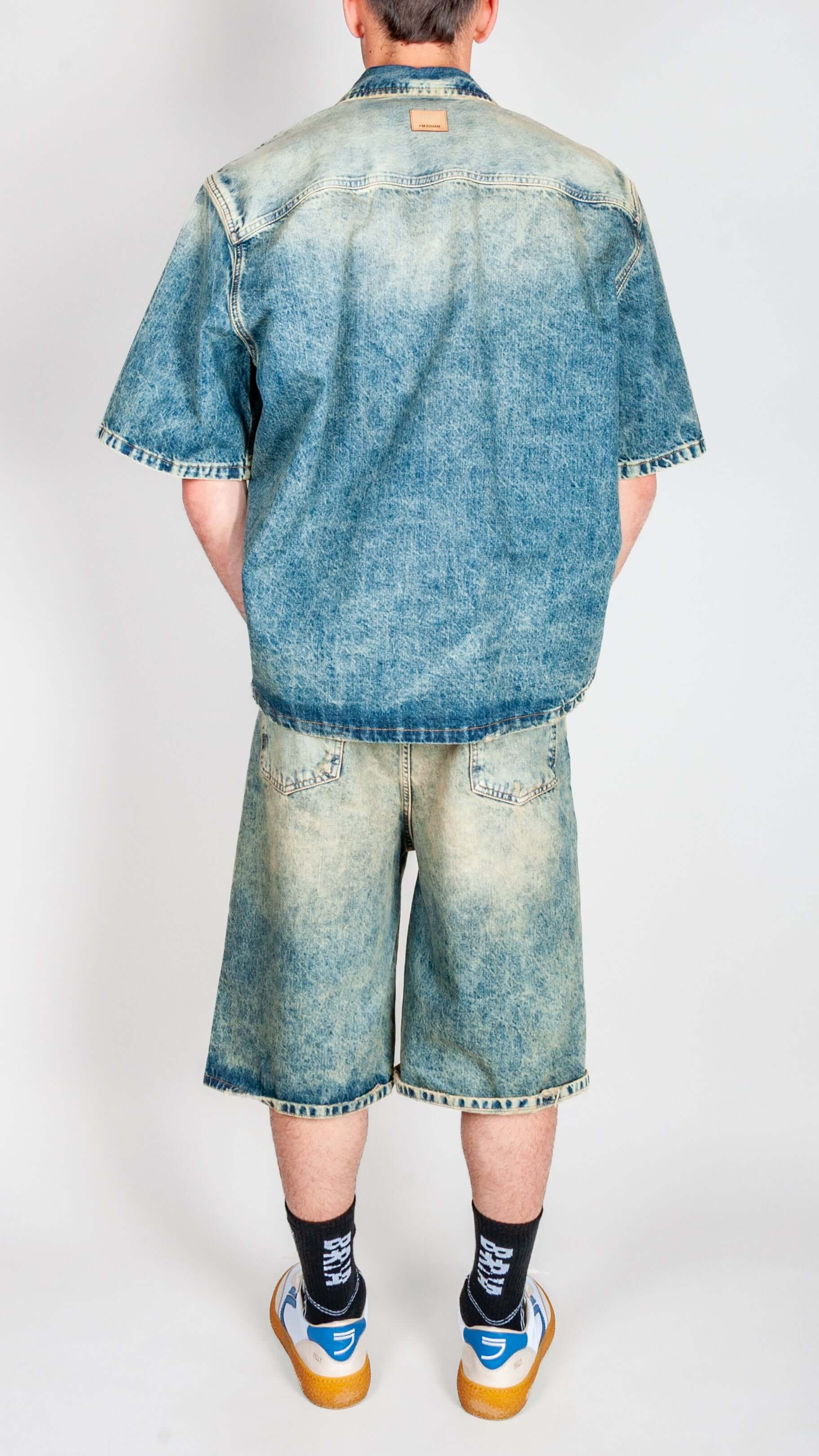 Completo in denim I'm Brian model from the back showcasing denim shirt and shorts.