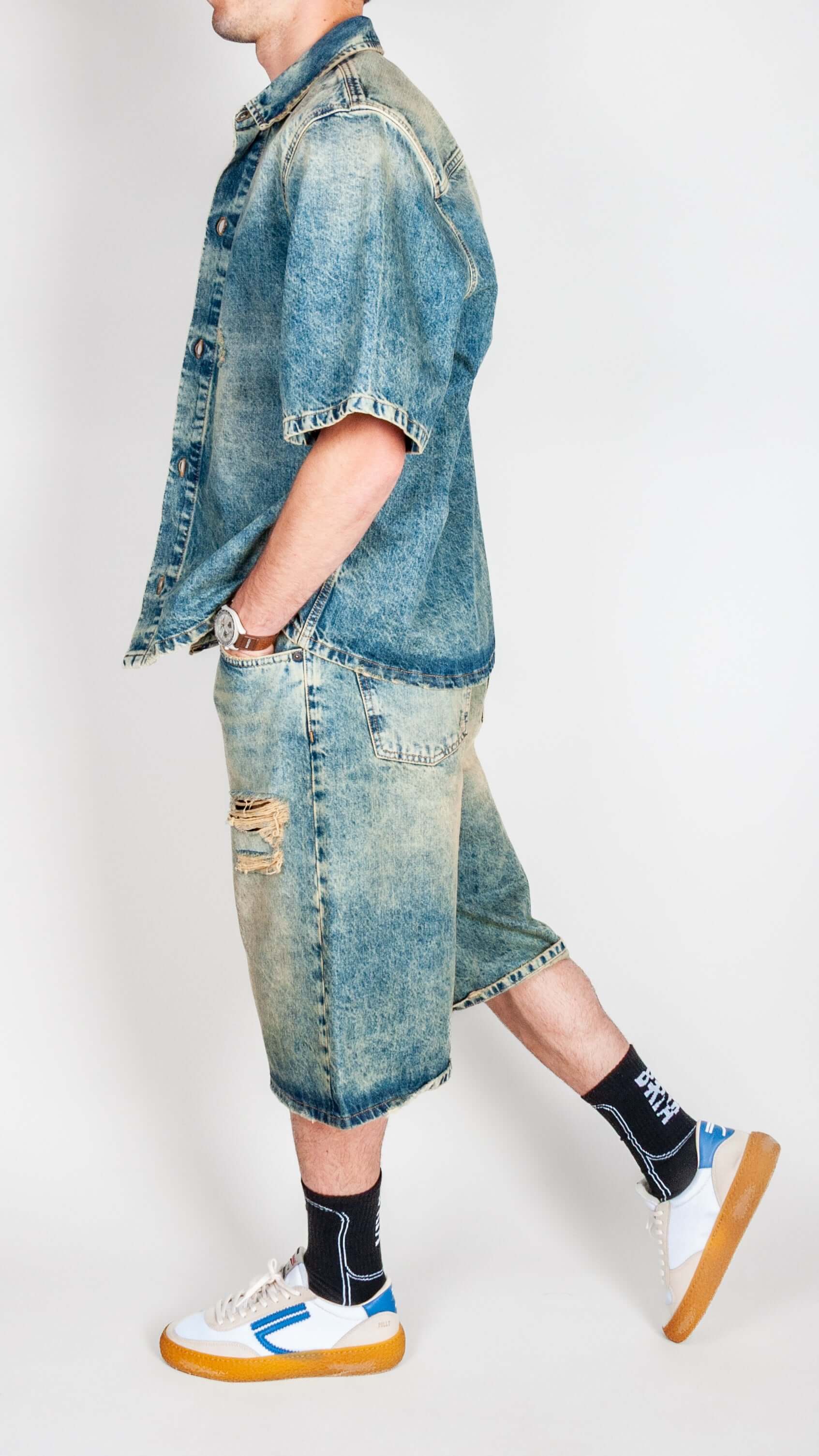 Model showcasing Completo in denim with a denim jacket and shorts, paired with stylish sneakers.
