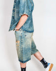 Model showcasing Completo in denim with a denim jacket and shorts, paired with stylish sneakers.