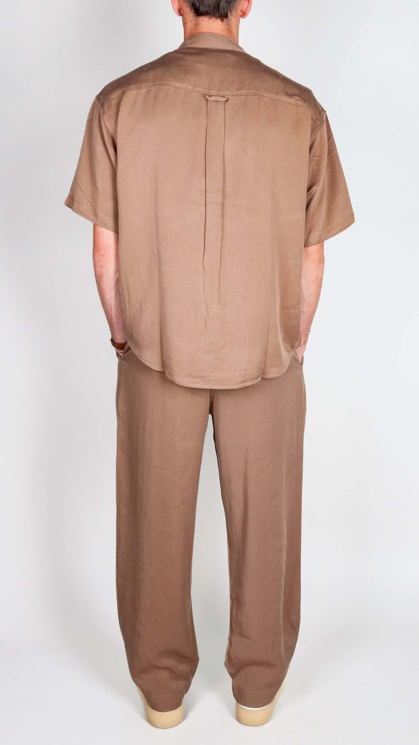 Completo in Lyocell Double Label Cammello worn by a man viewed from the back, showcasing a stylish brown outfit.