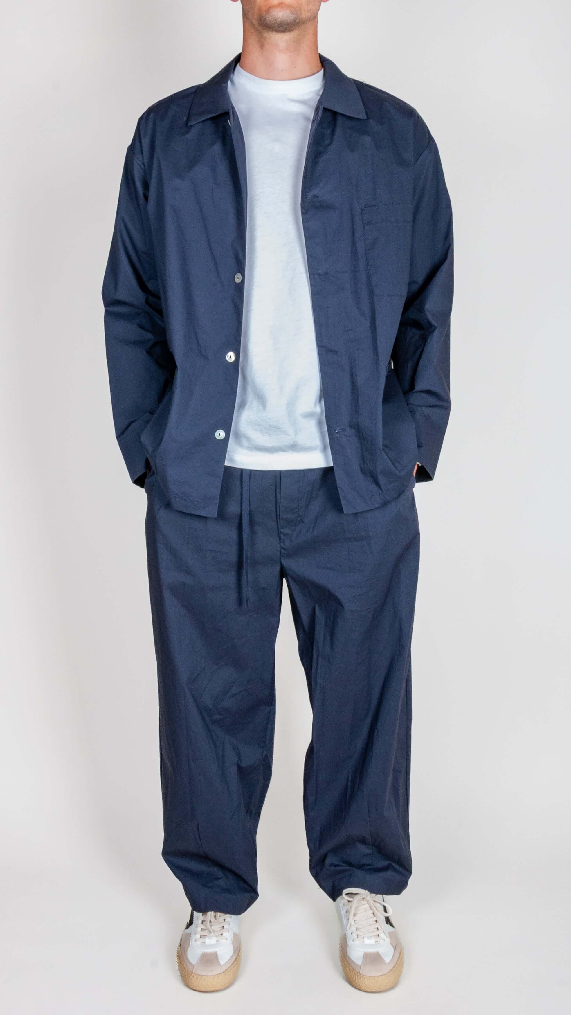 Model wearing Completo Popeline Imperial - Blu set, featuring a dark blue shirt and matching pants.