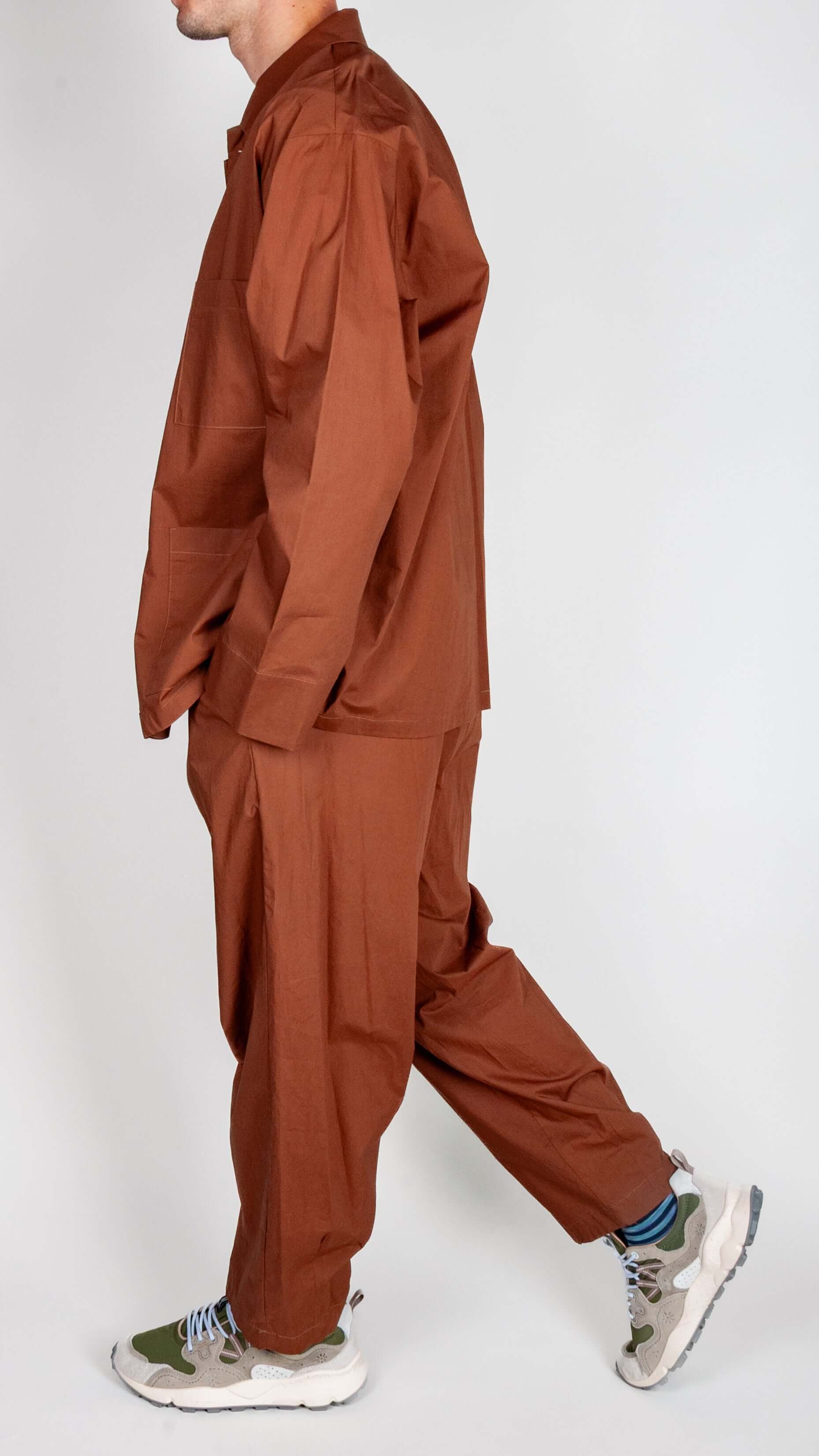 Completo Popeline Imperial - Moro worn by a model, showcasing a stylish brown outfit with sporty sneakers.