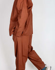 Completo Popeline Imperial - Moro worn by a model, showcasing a stylish brown outfit with sporty sneakers.