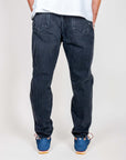 Jeans Jeremiah uomo neri usati cotone visti da dietro con scarpe blu.