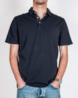Polo manica corta Piquet tinto capo Over D Art indossato da uomo con pantaloni di jeans.