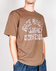 Model wearing a brown t-shirt Amish with face ghost university graphic, perfect for casual style.
